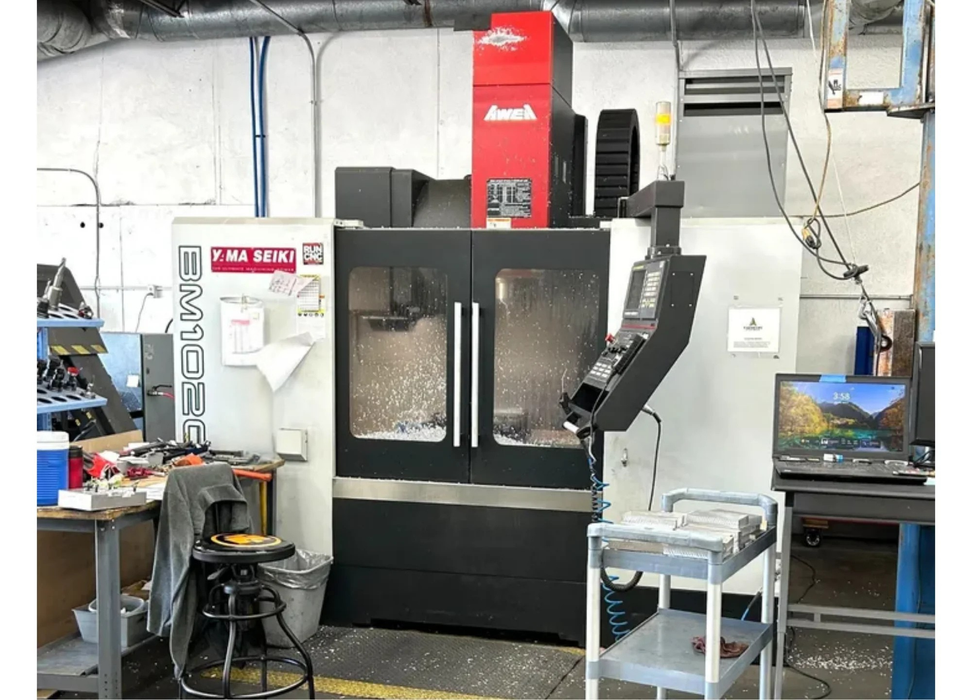 Machining center in a workshop with various equipment and tools.